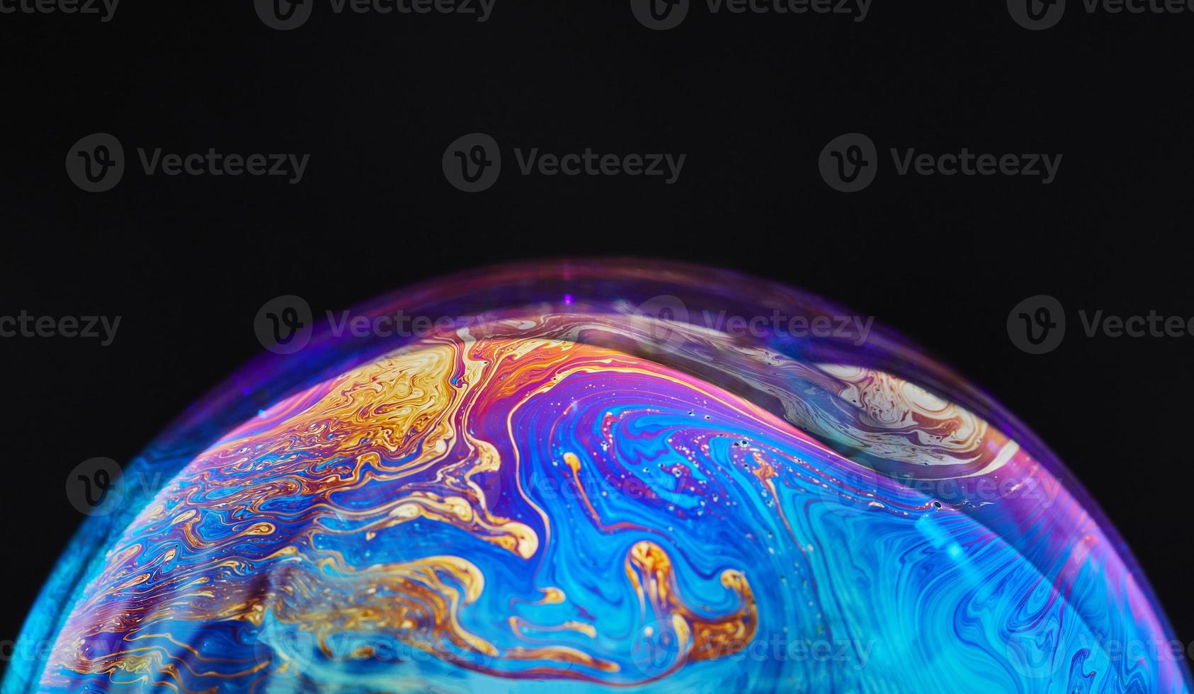 Virtual reality space with abstract multicolor psychedelic planet. Closeup Soap bubble like an alien planet on black background photo
