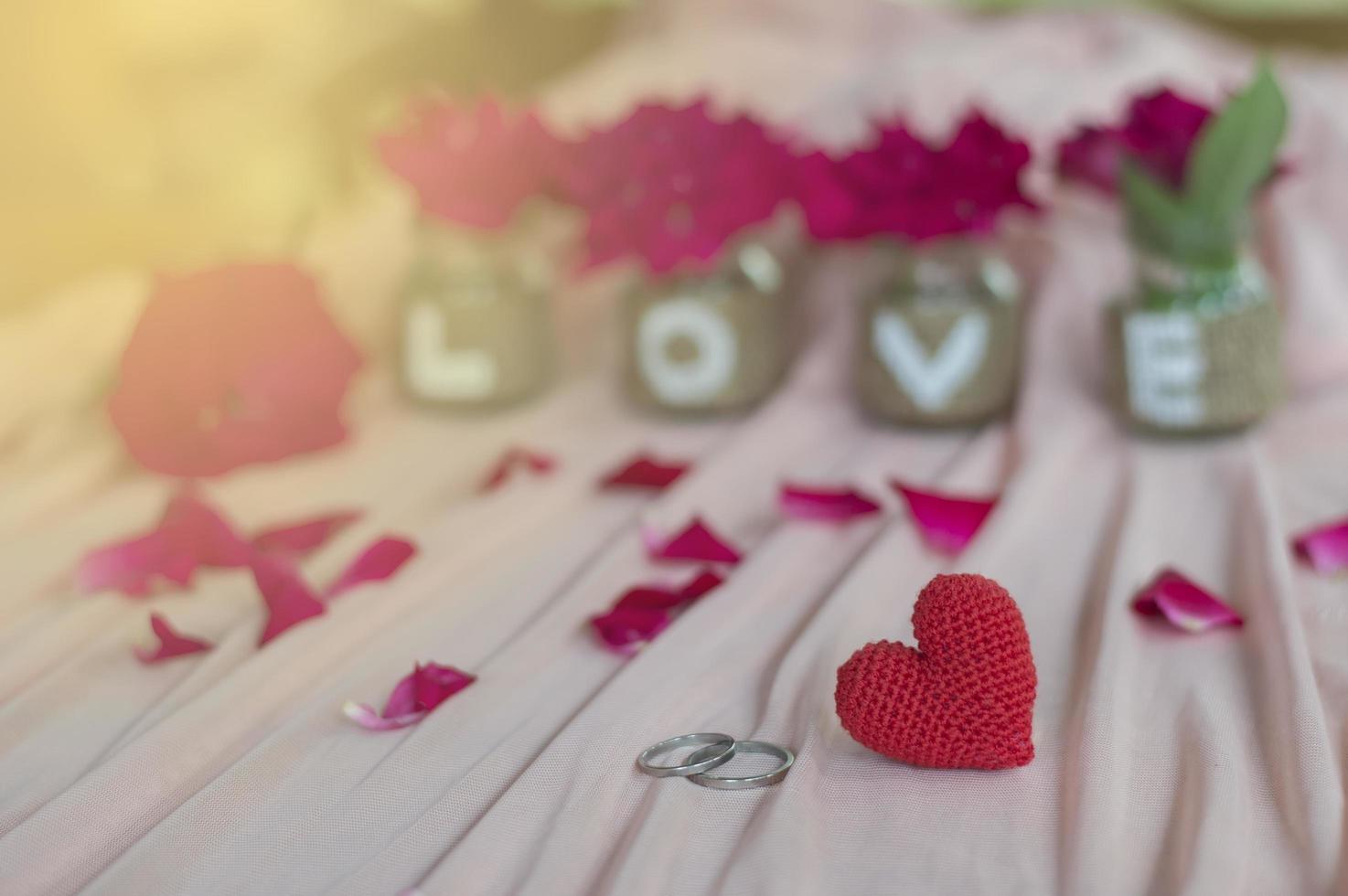 corazón rojo, anillos, rosa y blackborad en tela rosa para el día de san valentín o el fondo de la boda foto