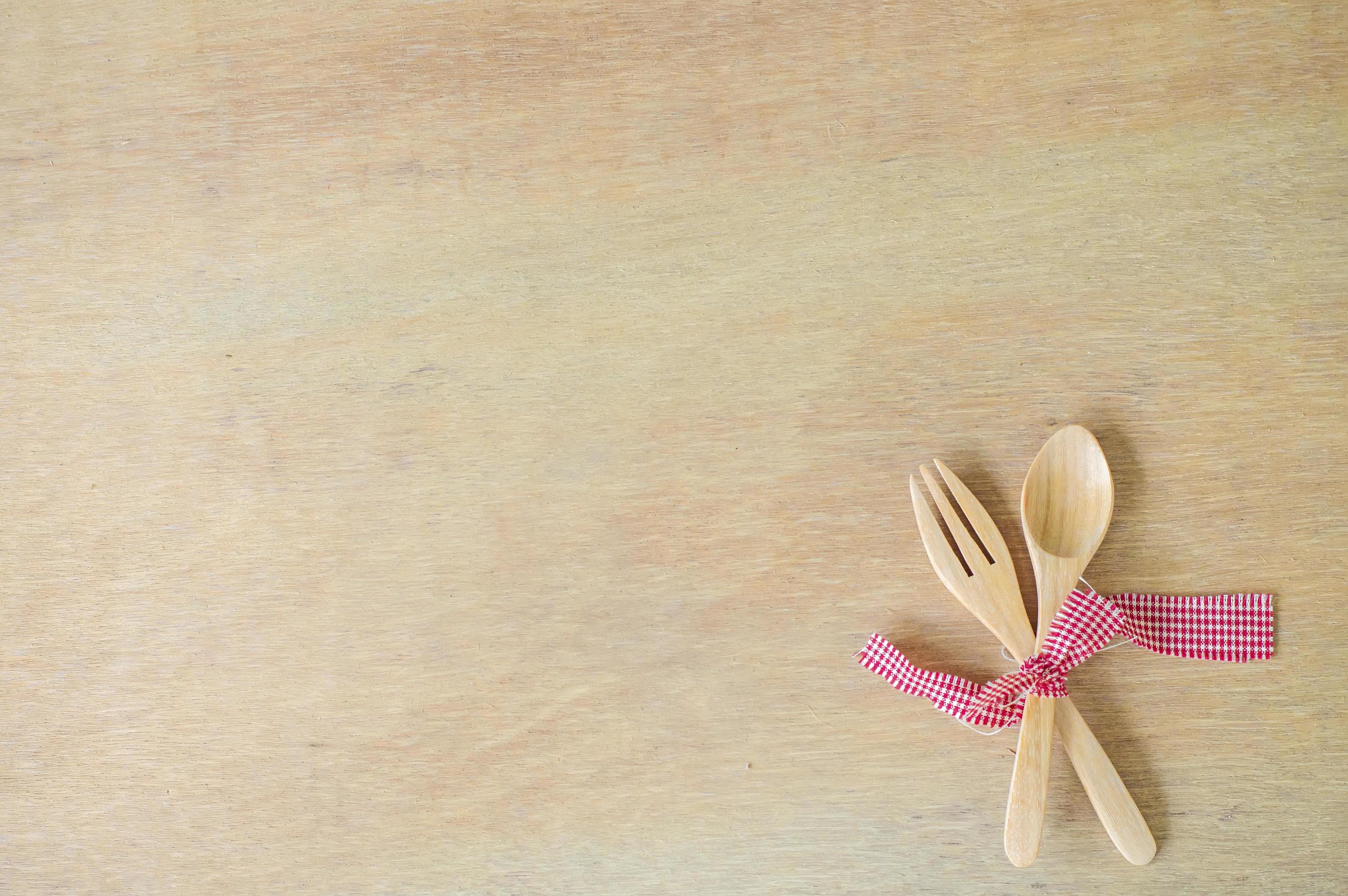Kitchen utensils. Wooden fork and spoon with red fabric on wooden