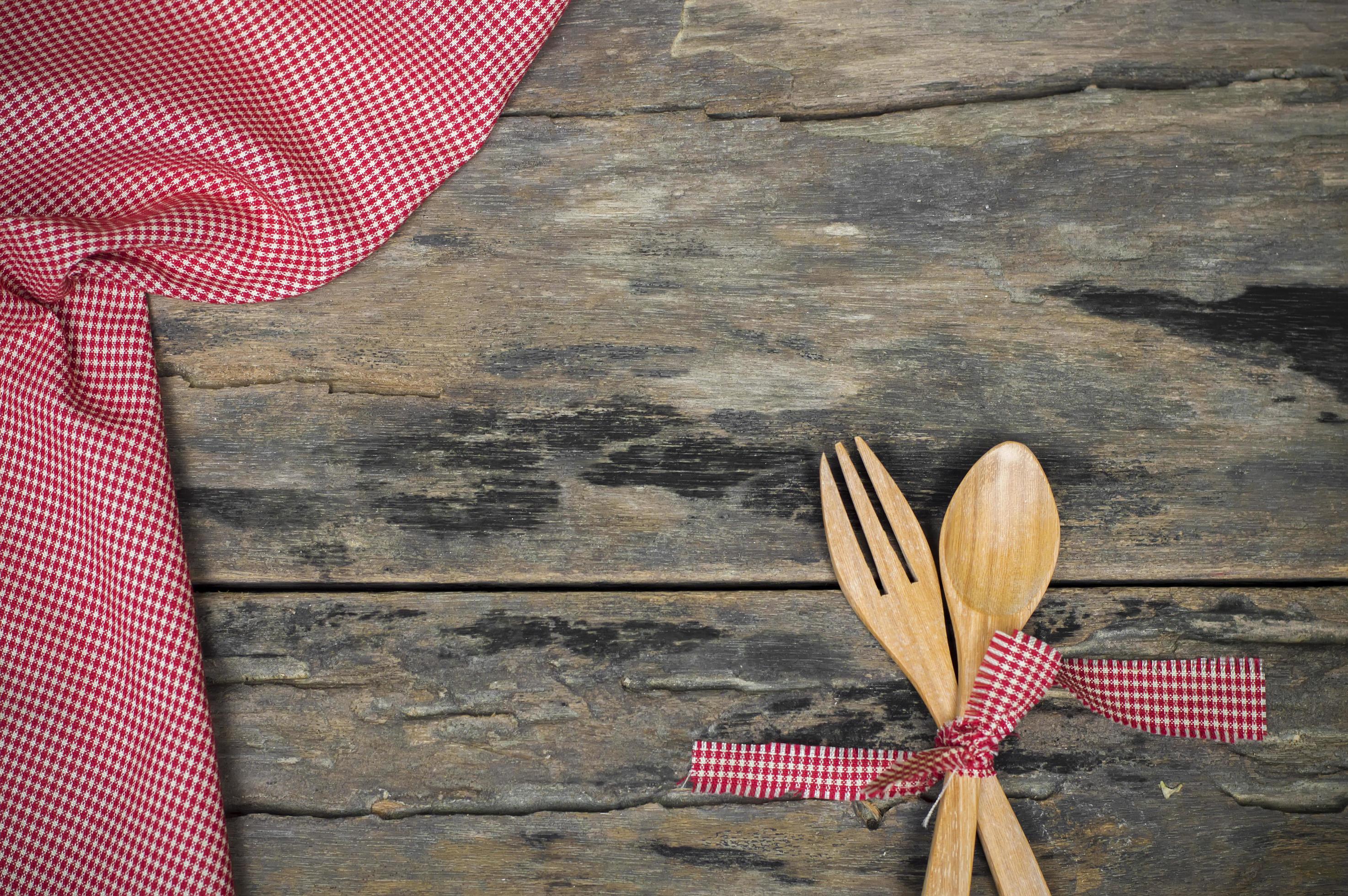 Kitchen utensils. Wooden fork and spoon with red fabric on wooden