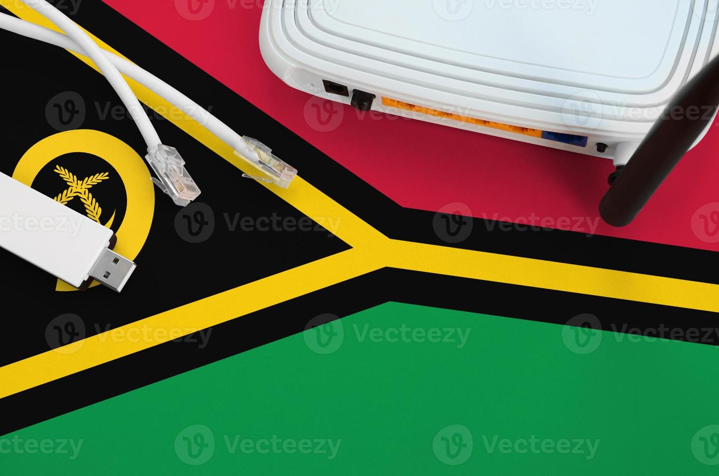 Vanuatu flag depicted on table with internet rj45 cable, wireless usb wifi adapter and router. Internet connection concept photo