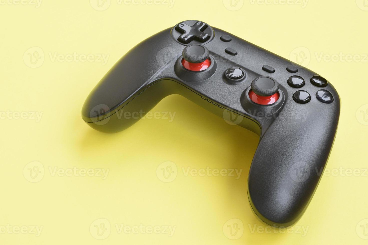 Modern black joystick on yellow background. Video game challenges and competitions concept photo