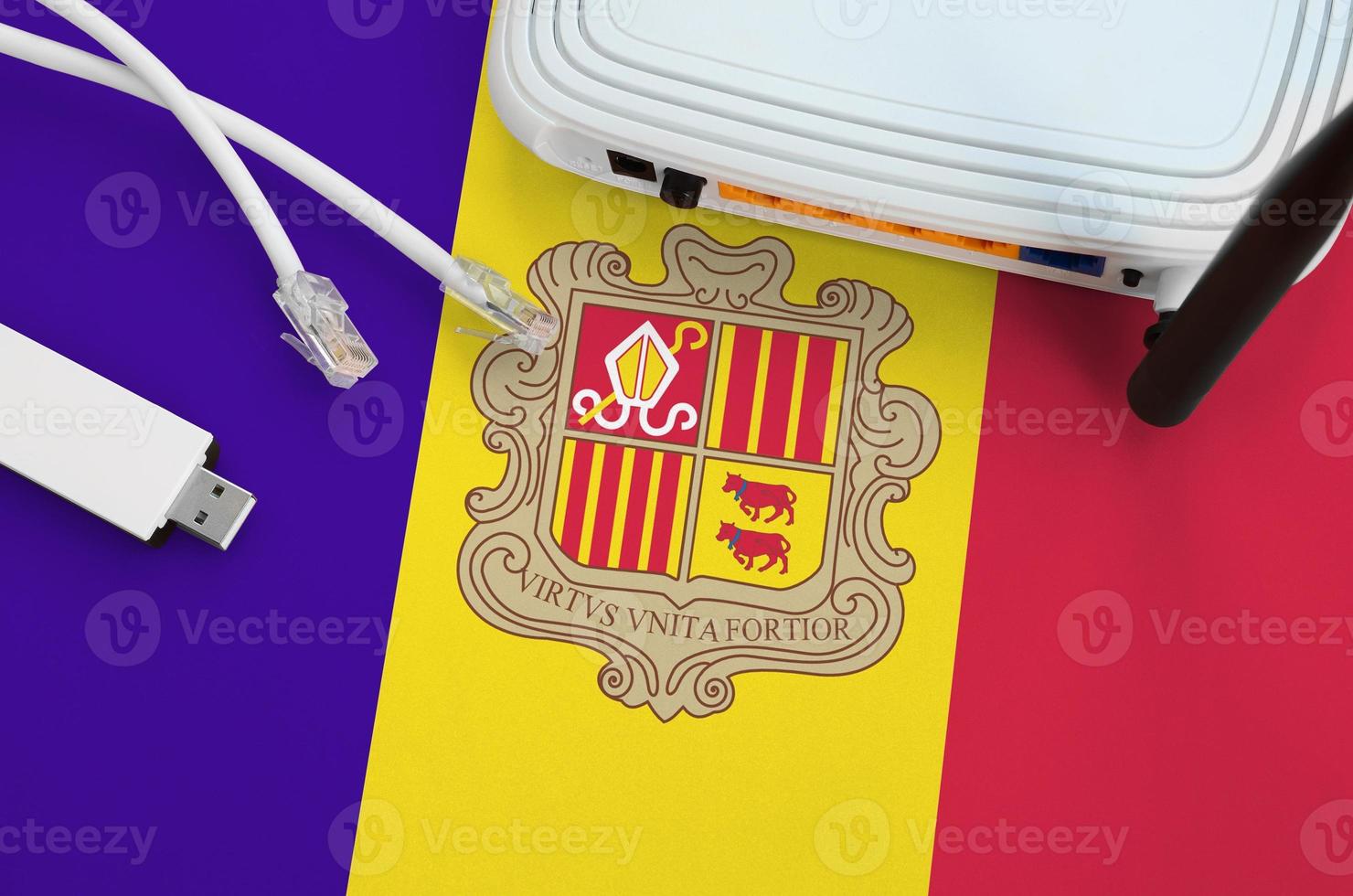 Andorra flag depicted on table with internet rj45 cable, wireless usb wifi adapter and router. Internet connection concept photo
