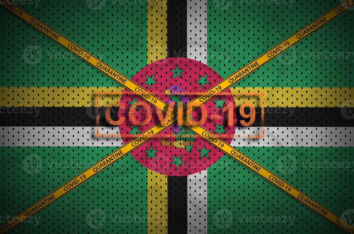 Dominica flag and Covid-19 stamp with orange quarantine border tape cross. Coronavirus or 2019-nCov virus concept photo