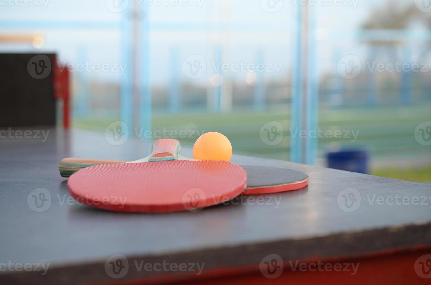 rackets and ball on Ping pong table in outdoor sport yard. Active sports and physical training concept photo