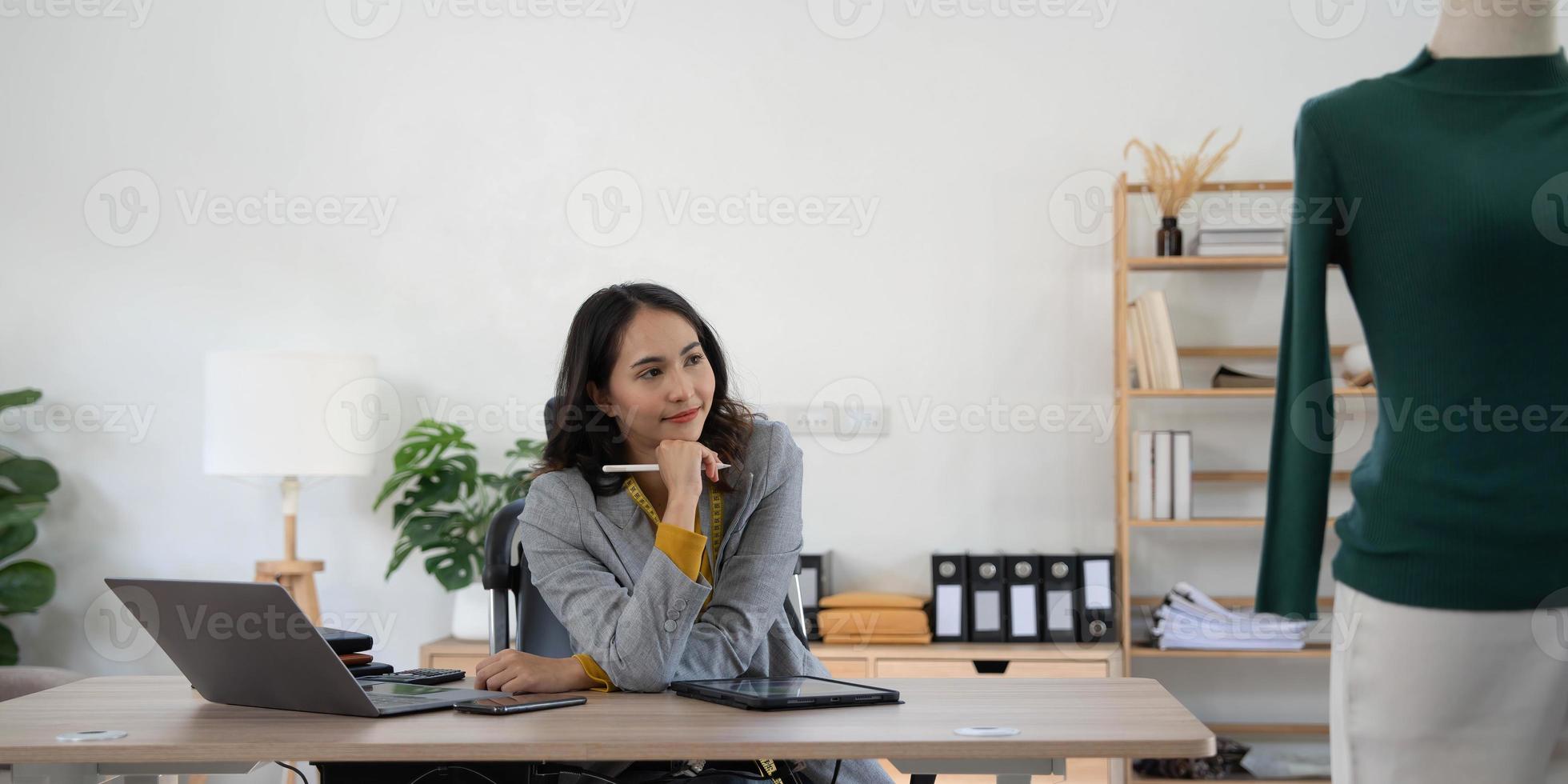 Smile designer, happy stylist asian young woman, girl using laptop computer check online order at home office, sell fashion clothes, owner of startup, entrepreneur e-commerce, small SME business. photo