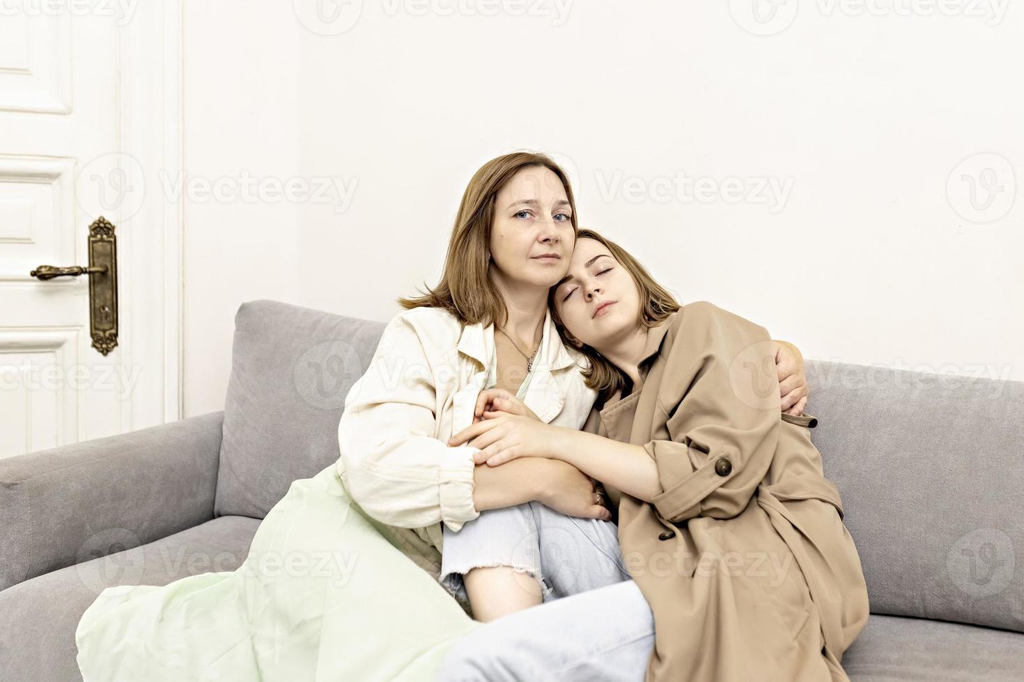 Parents and teens.Mom and teenage daughter are sitting on the couch. Conflict, difficult age. Family. photo