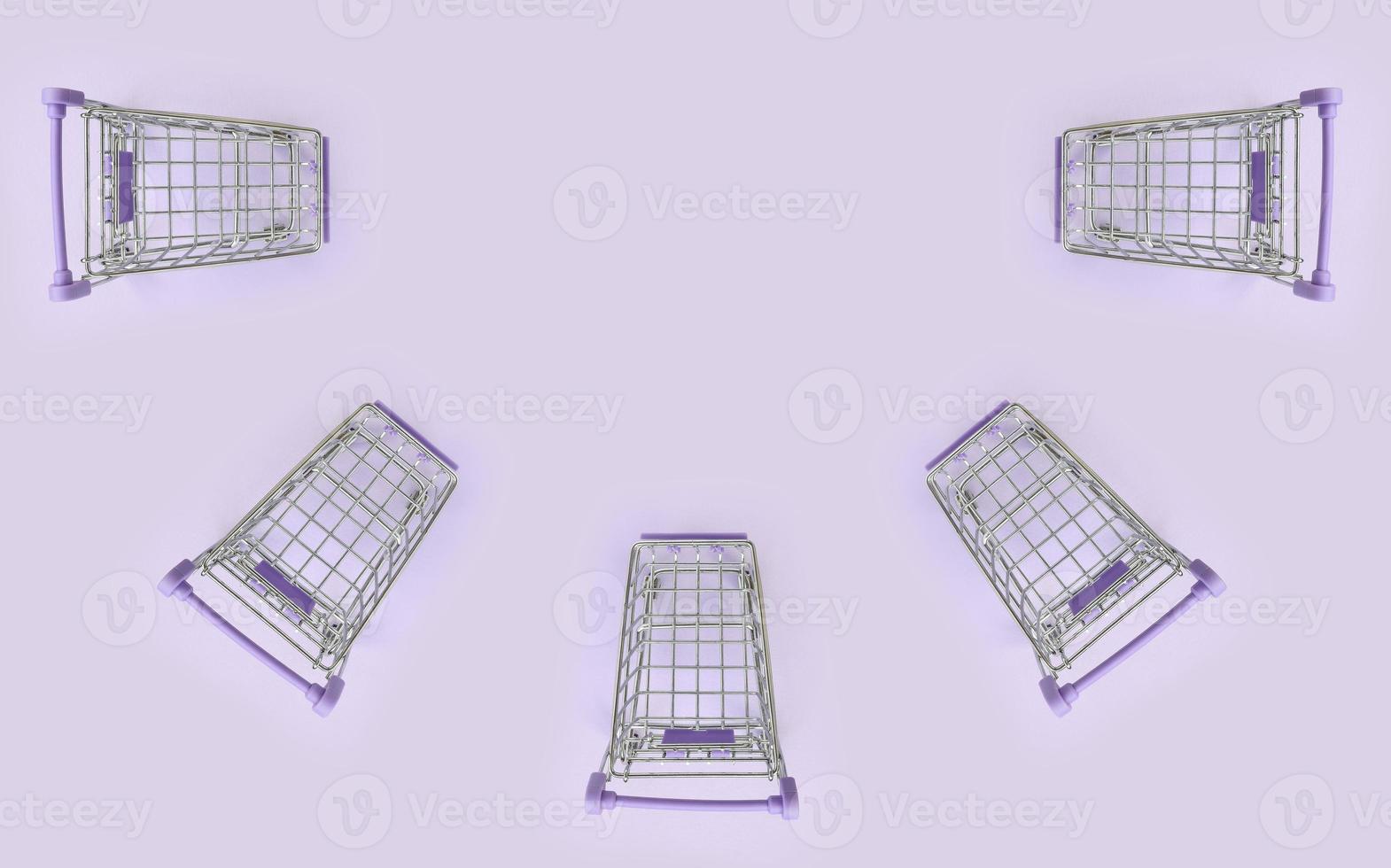 Pattern of many small shopping carts on a violet background. Minimalism flat lay top view photo
