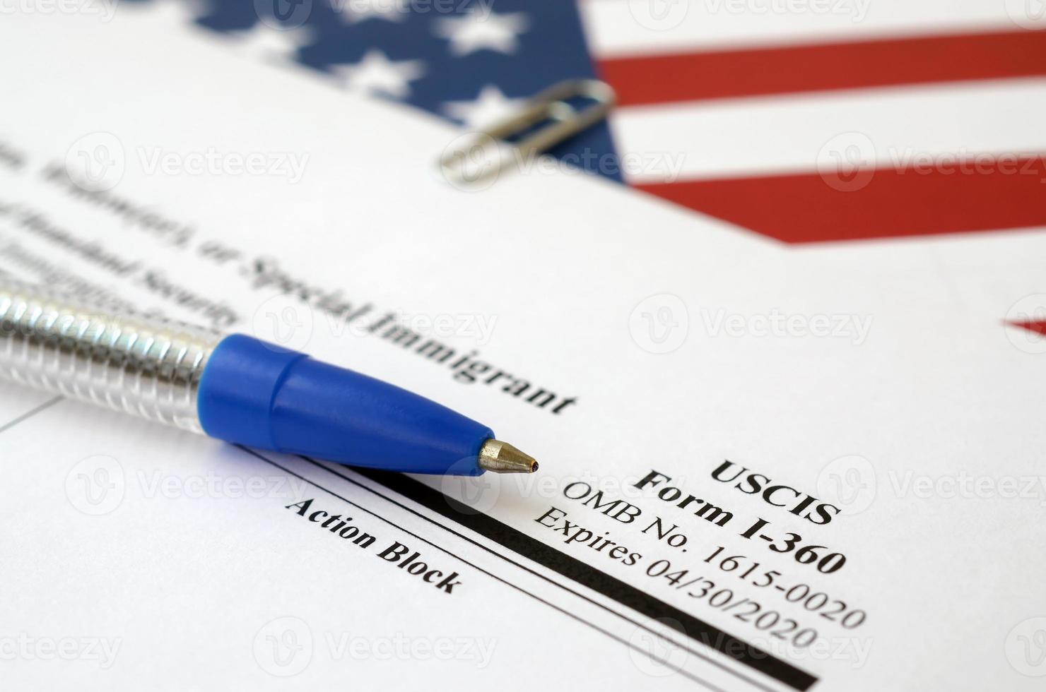 I-360 Petition for Amerasian, Widower or special immigrant blank form lies on United States flag with blue pen from Department of Homeland Security photo