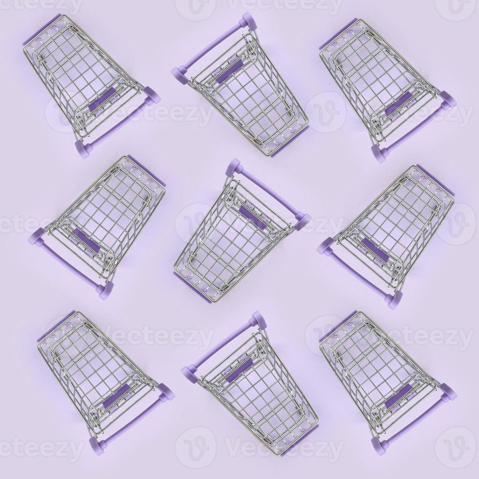 Pattern of many small shopping carts on a violet background. Minimalism flat lay top view photo
