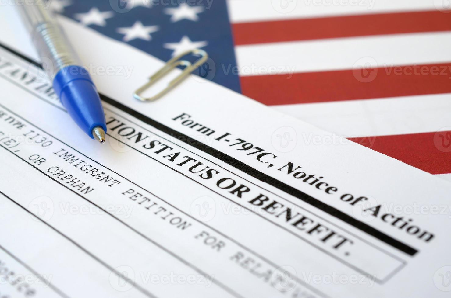 I-797c Notice of action blank form lies on United States flag with blue pen from Department of Homeland Security photo