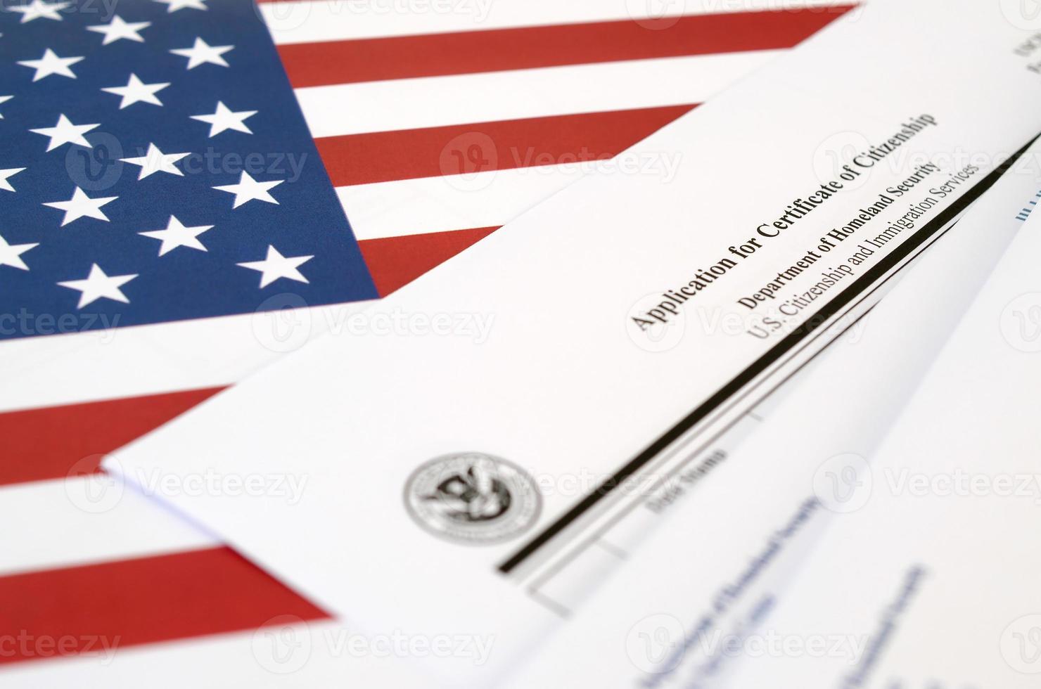 N-600 Application for Certificate of Citizenship blank form lies on United States flag with envelope from Department of Homeland Security photo