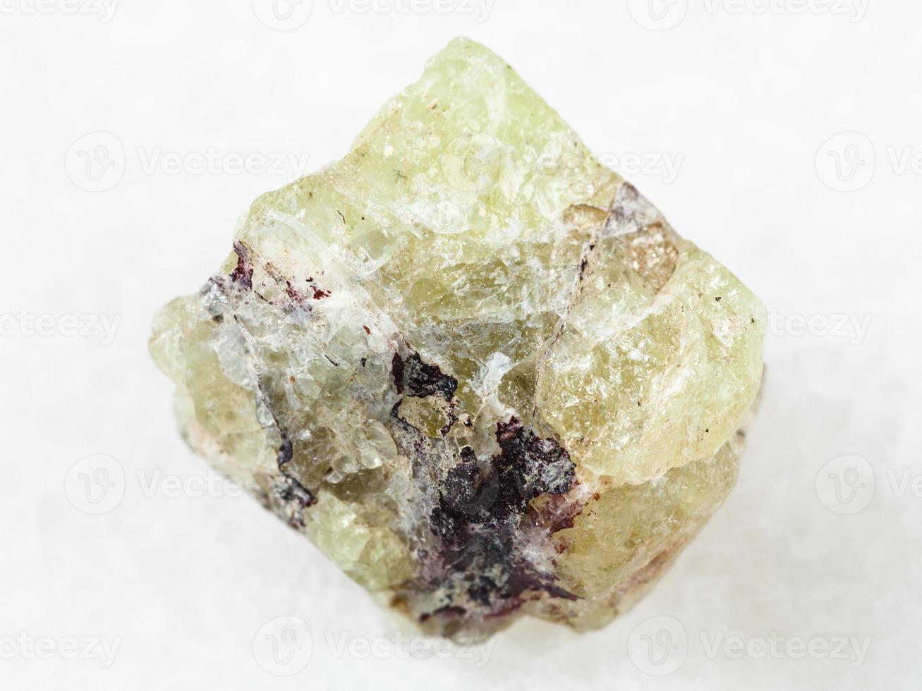 rough crystal of Saamite fluorapatite on white photo