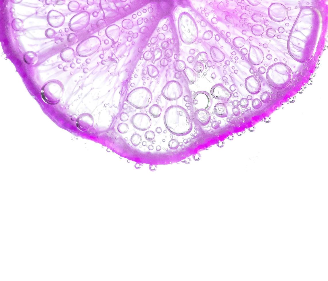 jugosas rodajas de lima con burbujas bajo el agua aisladas en fondo blanco. rodajas de limón púrpura patrón de fondo texturizado. foto