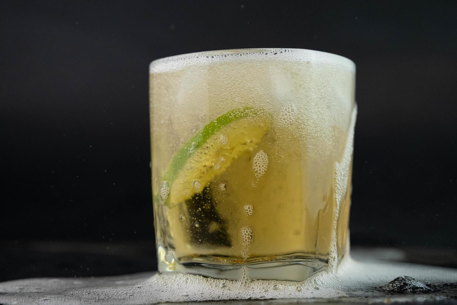 tiro de tequila mexicano dorado con limón y sal sobre fondo negro. un