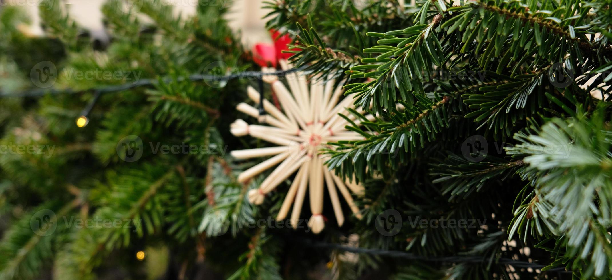 Christmas banner with Eco decor - Christmas tree pendant toy - straw snowflake. Copy space for greeting card. Perfect content for advertising banners, gift card or creative projects. Selective focus. photo