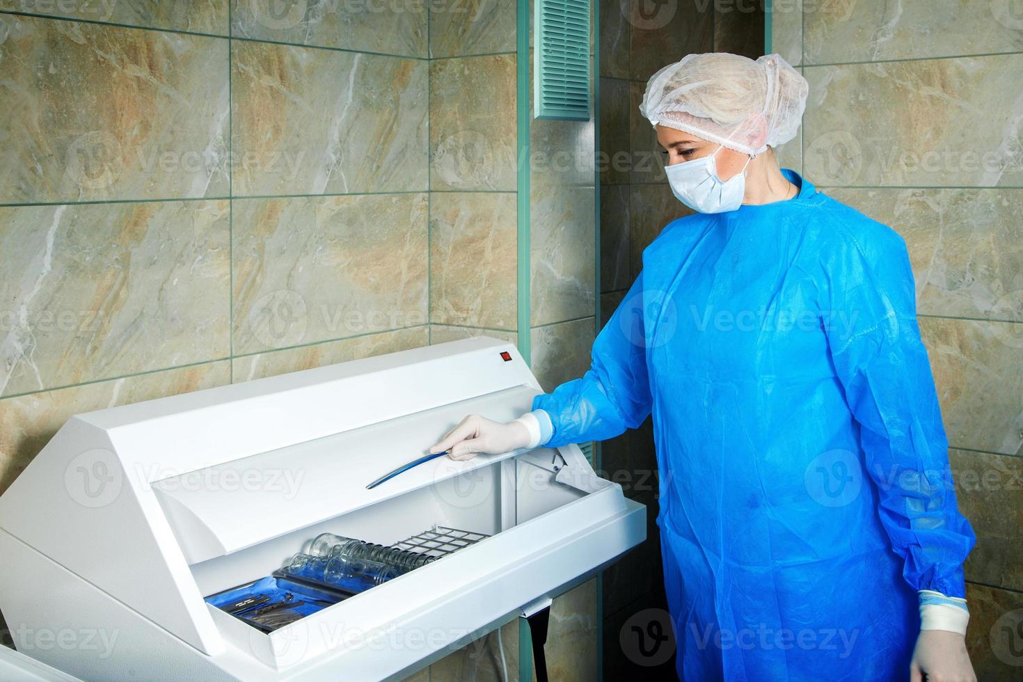 woman doctor gets sterile items required for operation photo