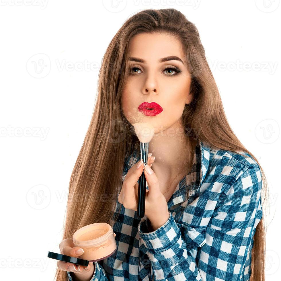 Girl plays with powder and makeup brushes photo