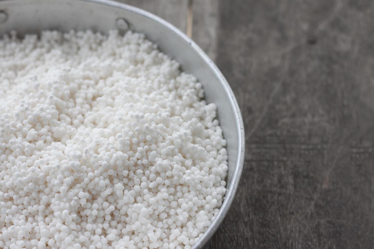 Dry tapioca pearls for make dessert, Thailand call Sago in tray on wooden table. photo