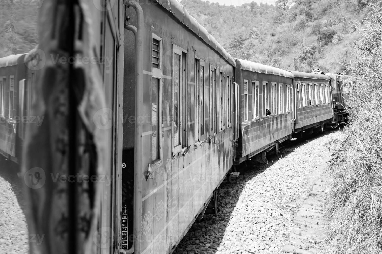 Toy Train moving on mountain slope, beautiful view, one side mountain, one side valley moving on railway to the hill, among green natural forest.Toy train from Kalka to Shimla in India-Black and White photo