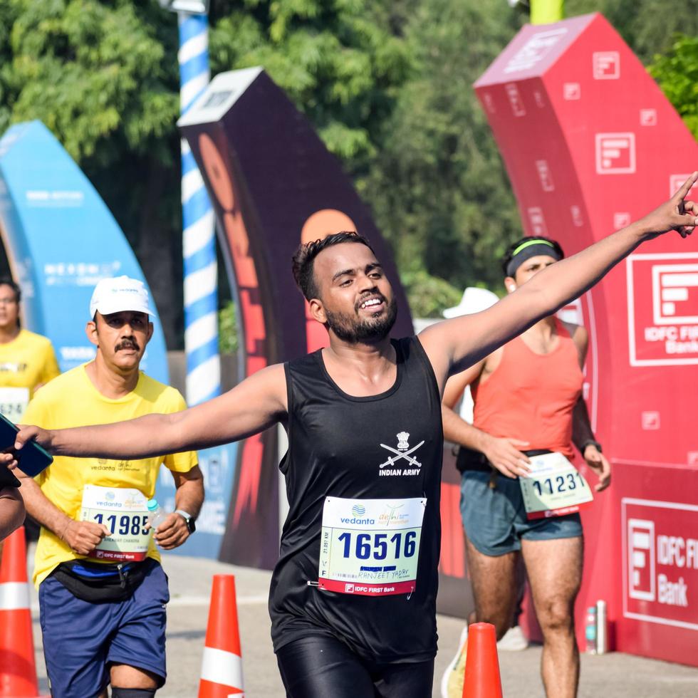 nueva delhi, india - 16 de octubre de 2022 - carrera de media maratón de vedanta delhi después de covid en la que los participantes del maratón están a punto de cruzar la línea de meta, media maratón de delhi 2022 foto