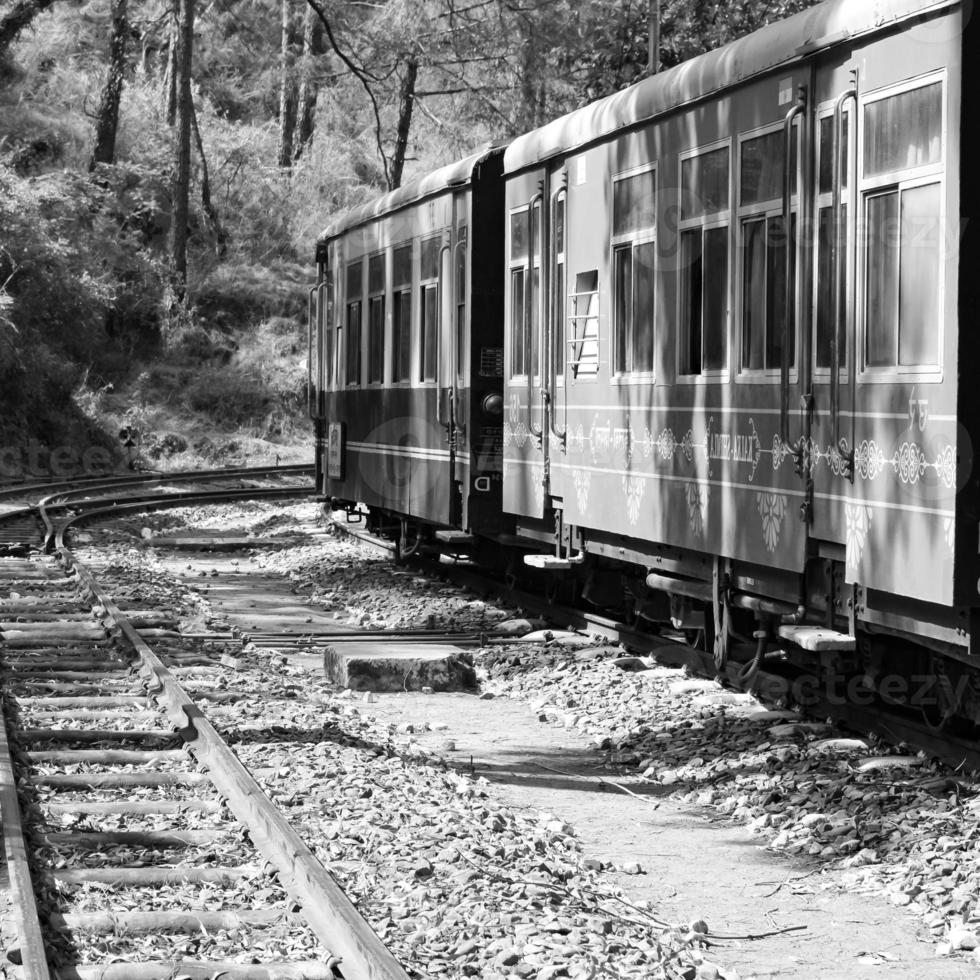 Toy Train moving on mountain slope, beautiful view, one side mountain, one side valley moving on railway to the hill, among green natural forest.Toy train from Kalka to Shimla in India-Black and White photo