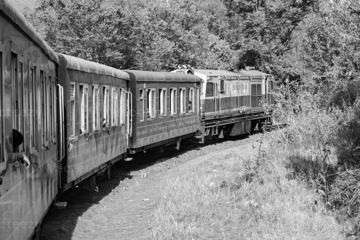 tren de juguete moviéndose en la ladera de la montaña, hermosa vista, montaña de un lado, valle de un lado moviéndose en ferrocarril a la colina, entre bosques naturales verdes.tren de juguete de kalka a shimla en india-blanco y negro foto