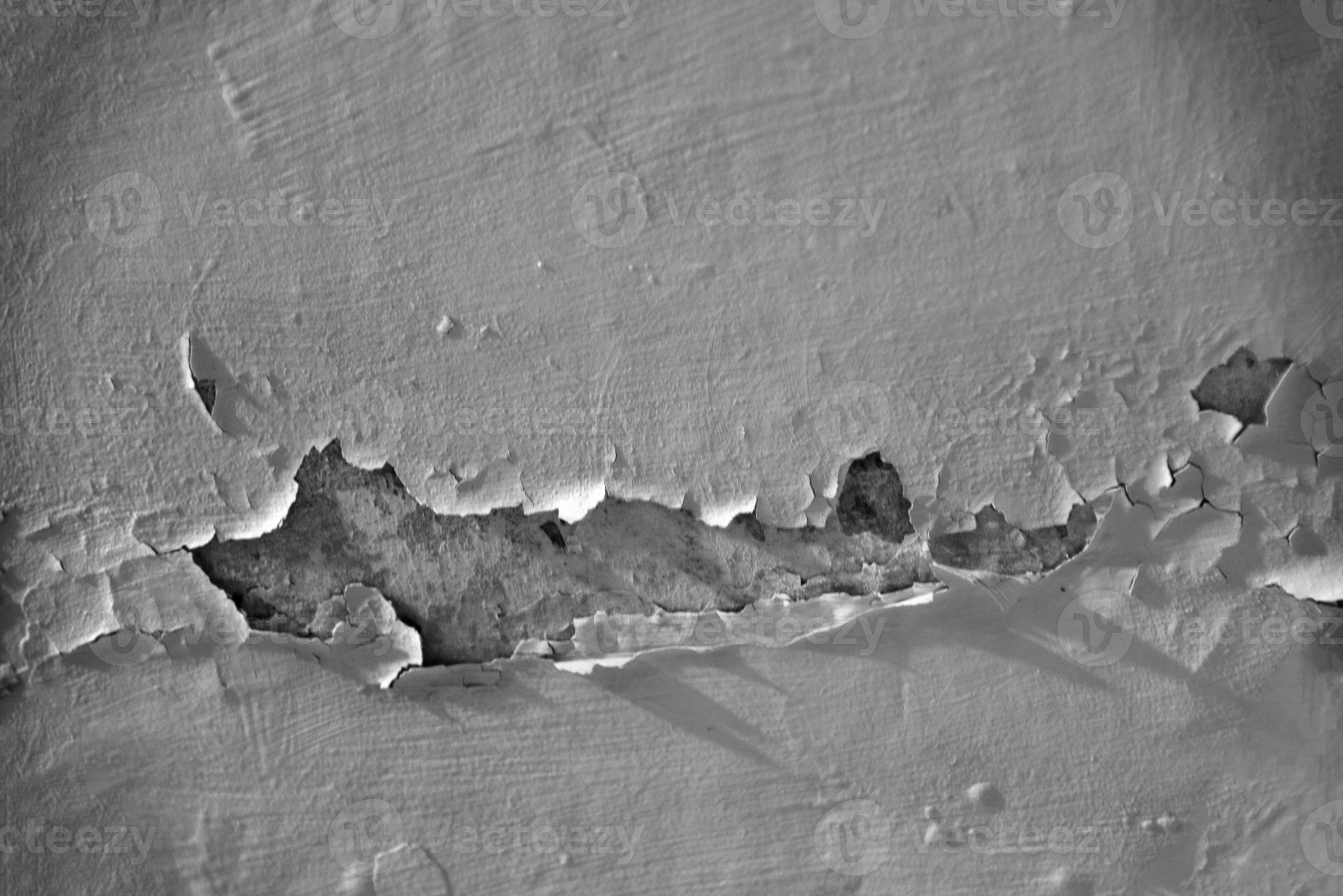 A whitewashed wall in the bathroom with cracks from water drips. Wall