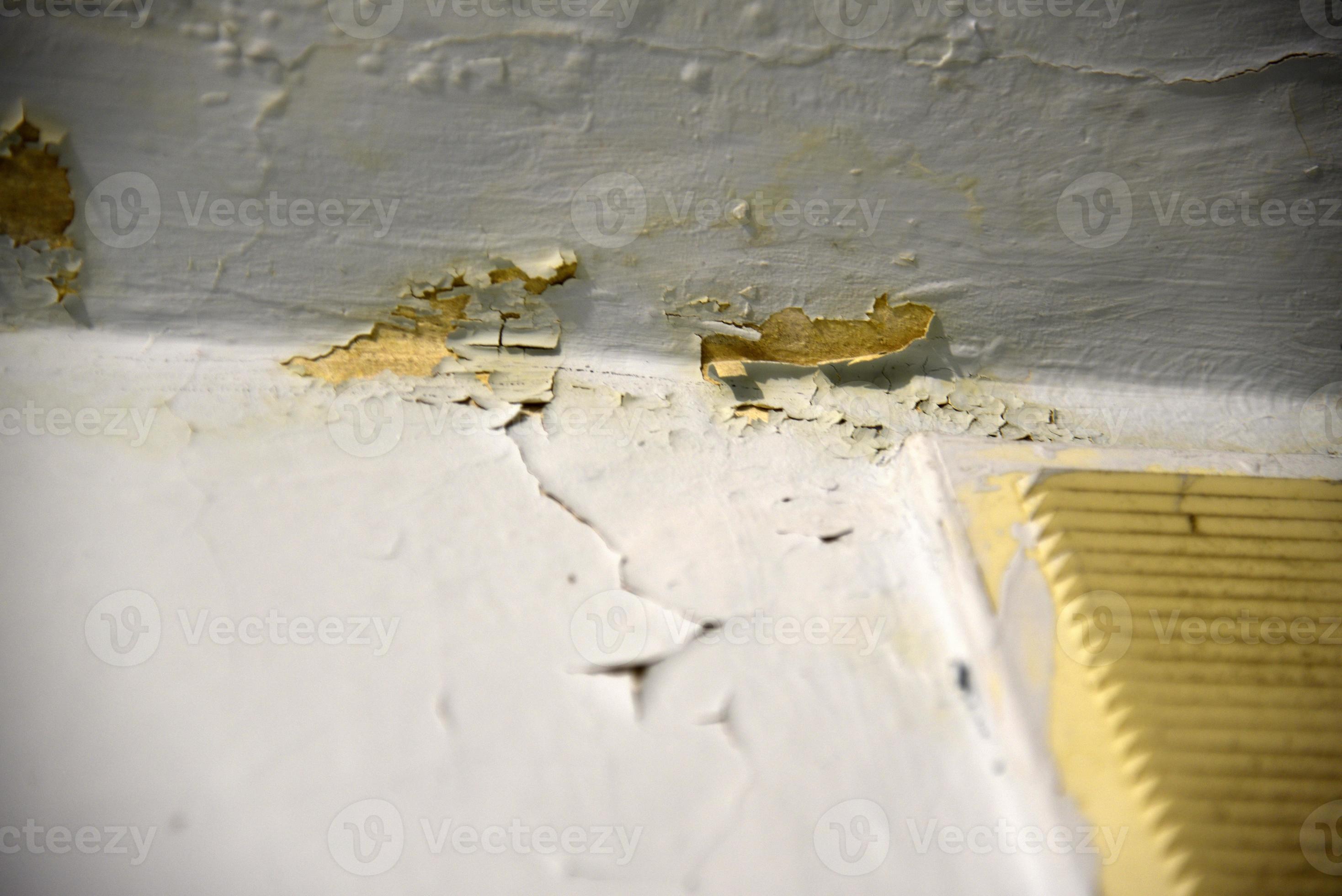 A whitewashed wall in the bathroom with cracks from water drips. Wall