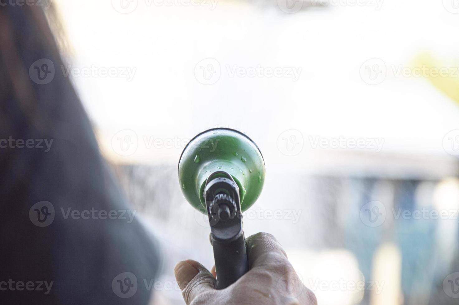 Picture of a gardener using water spray to water the plants. photo