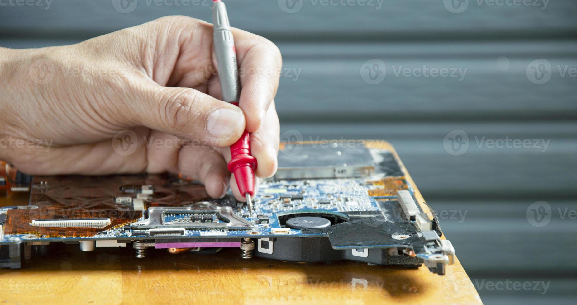 side view mechanic repairing motherboard photo