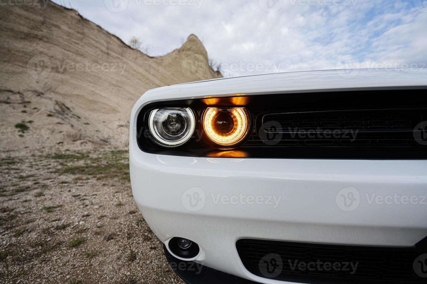 faros redondos de un potente coche deportivo americano blanco en carrera. foto