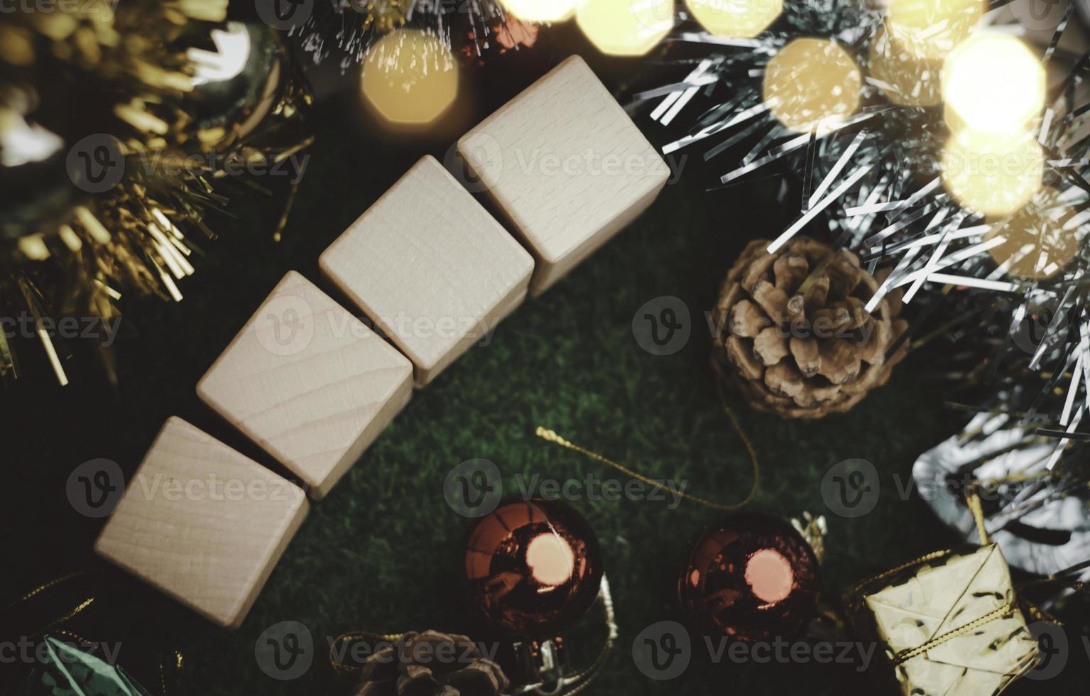 árbol de navidad y bolas de caja de regalo. guirnaldas de bokeh en el fondo borroso. bloque de cubo para contener el propósito de hacer negocios superando. desarrollando ideas para el nuevo año 2023 foto