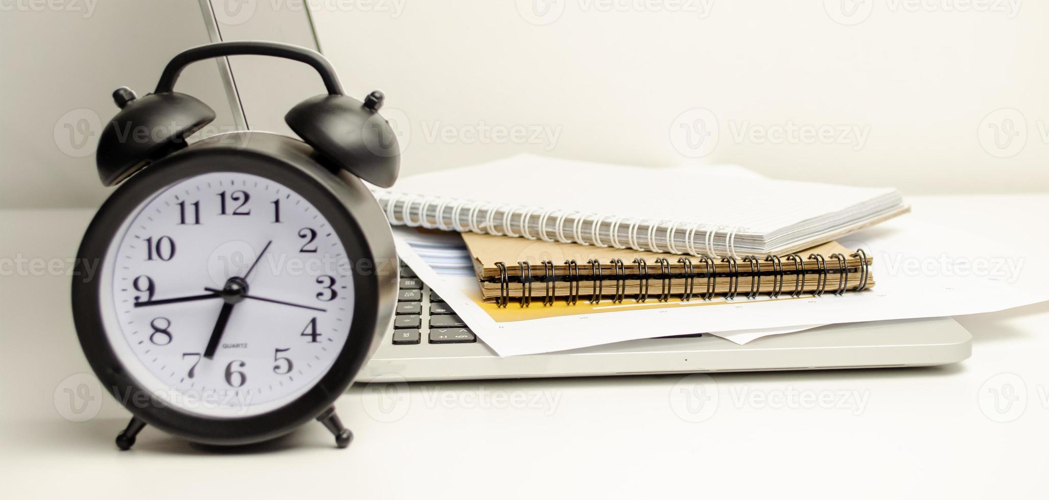 Working desk, Office and home office concept. with Laptop, Pencil, Clock, Milk cup on wooden table. photo