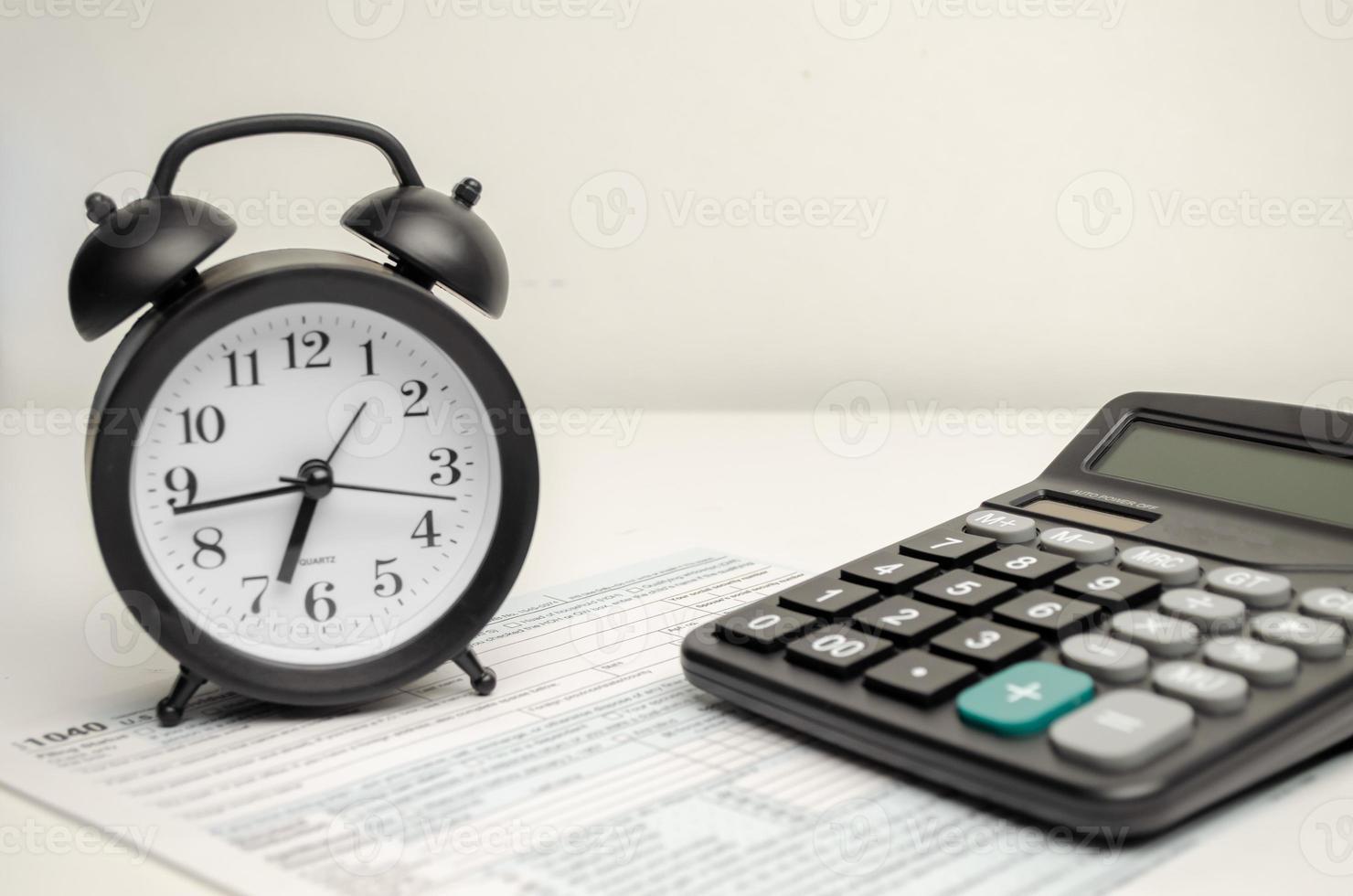 1040 Individual income tax return form and black alarm clock photo