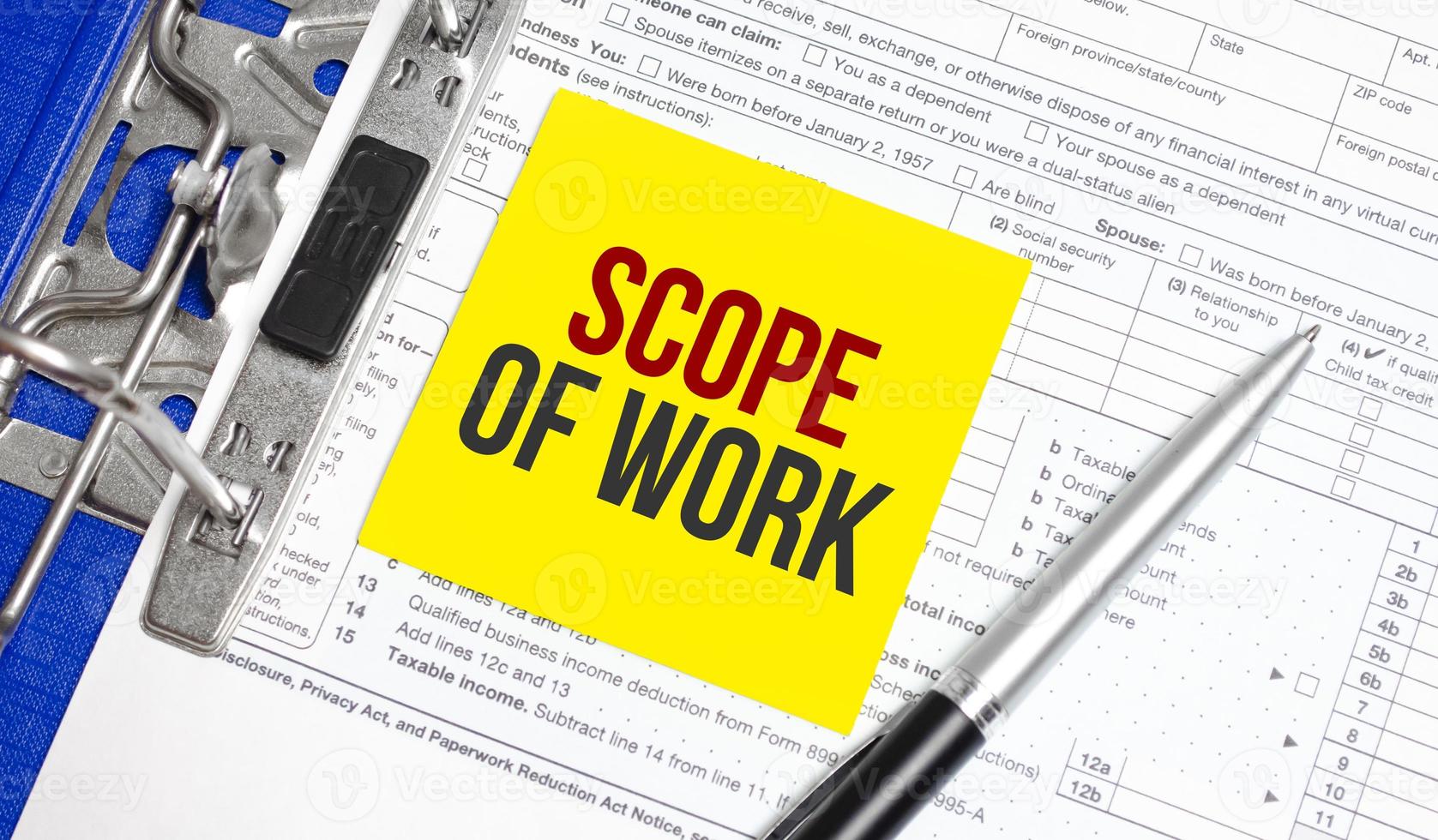Scope Of Work words on yellow sticker with tax forms and pen photo