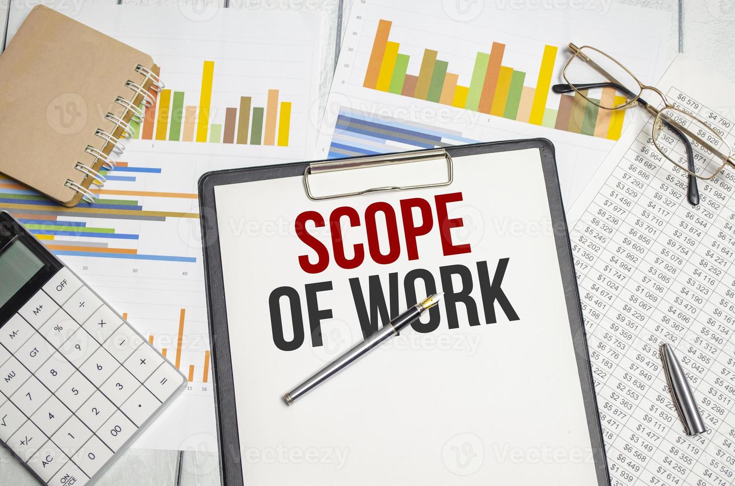 Scope Of Work words on paper tablet. Conceptual background with chart ,papers and pen photo