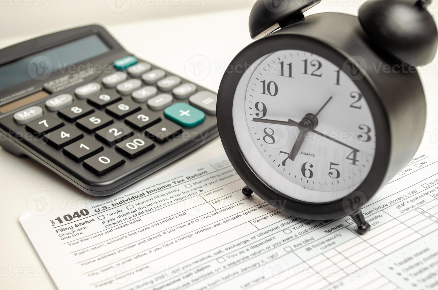 Tax form with clock, pen and calculator on white background. Business concept. photo