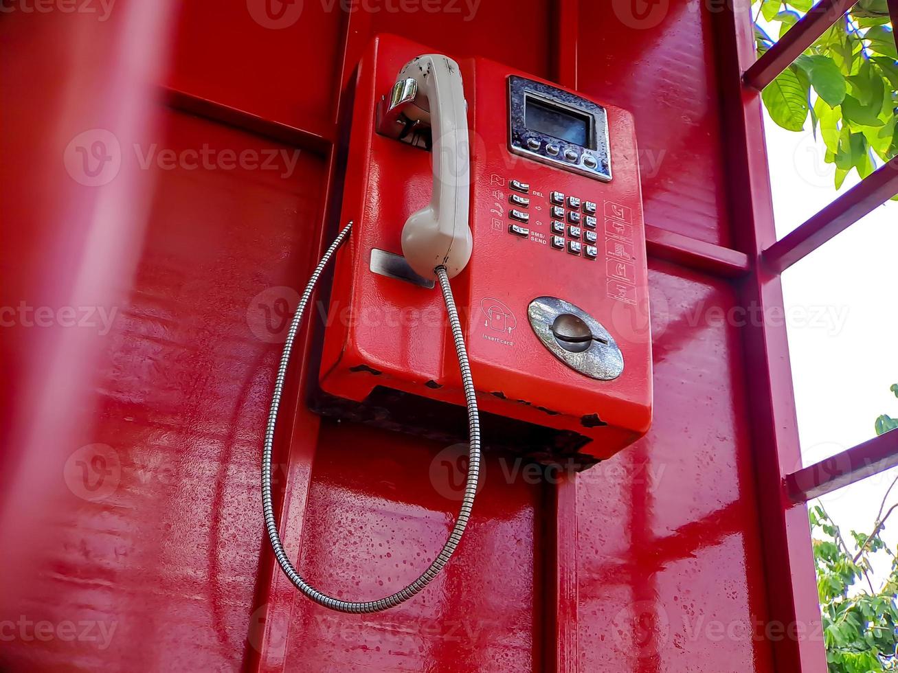 The old red wired telephone in the past, it's like going back to the past where people often used public telephones. photo
