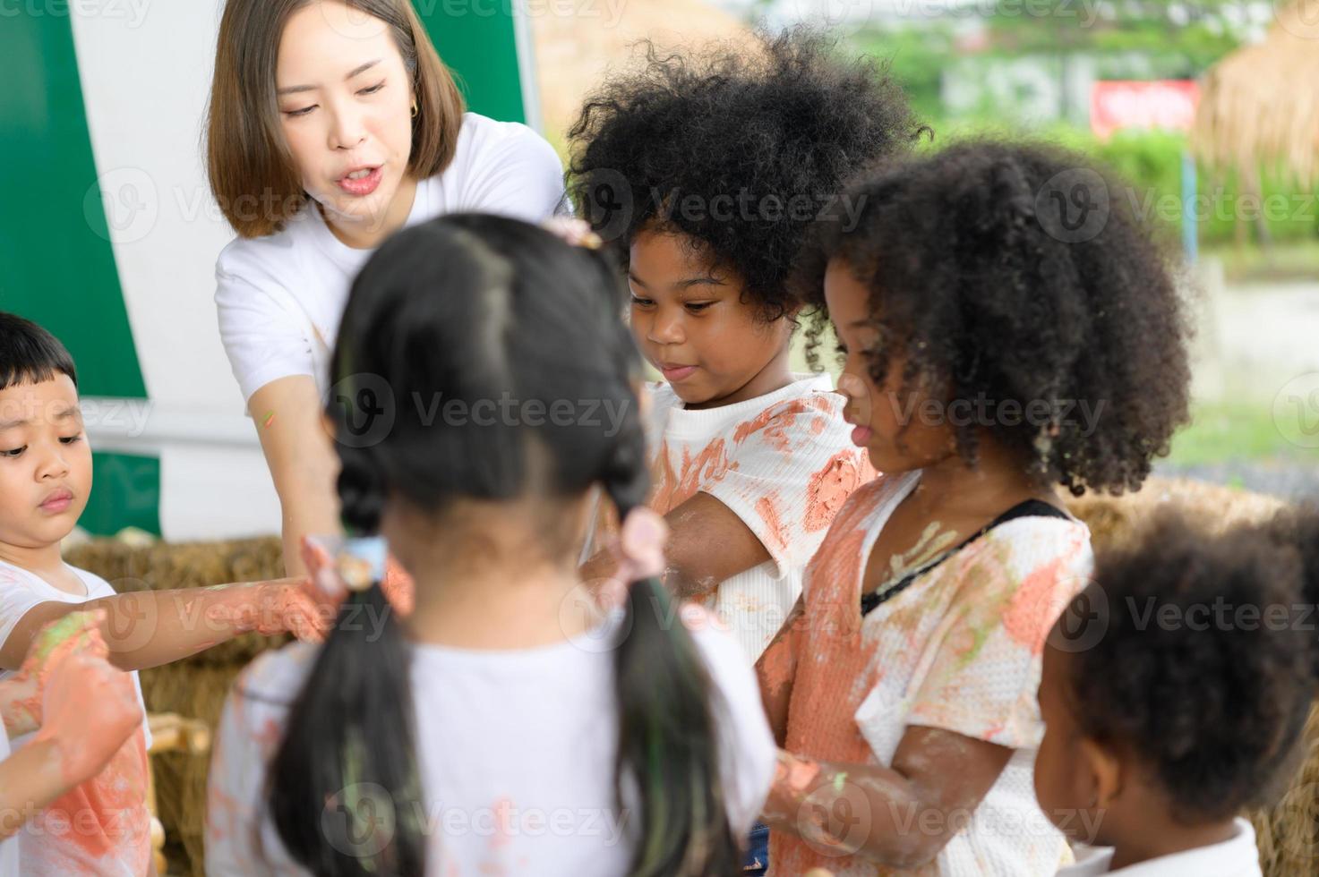 Children have fun playing with colors. They are holding hands photo