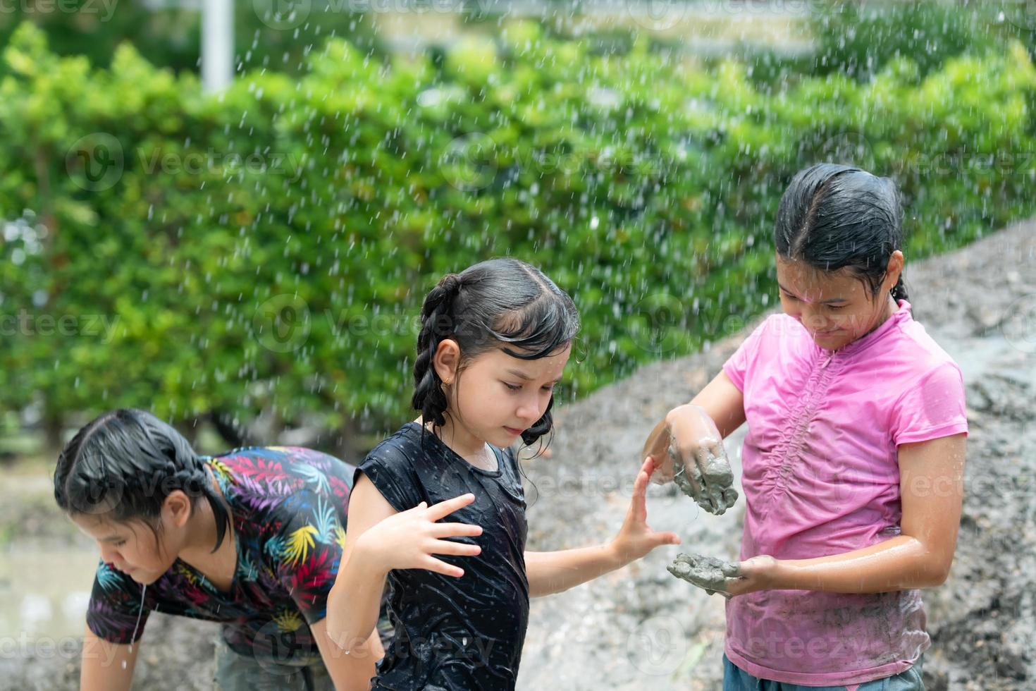 Little girls have fun playing in the mud in the community fields photo