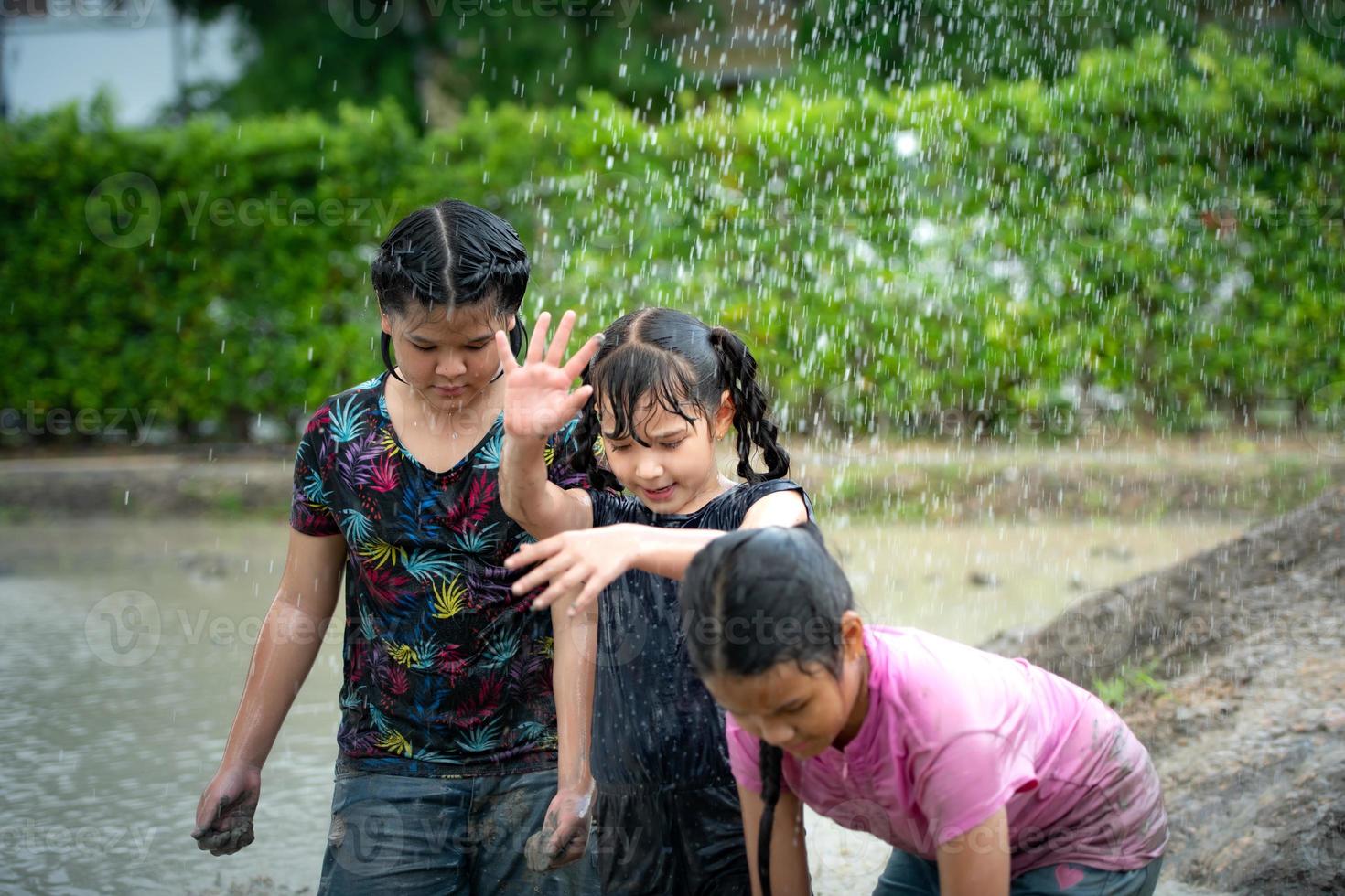 Little girls have fun playing in the mud in the community fields photo