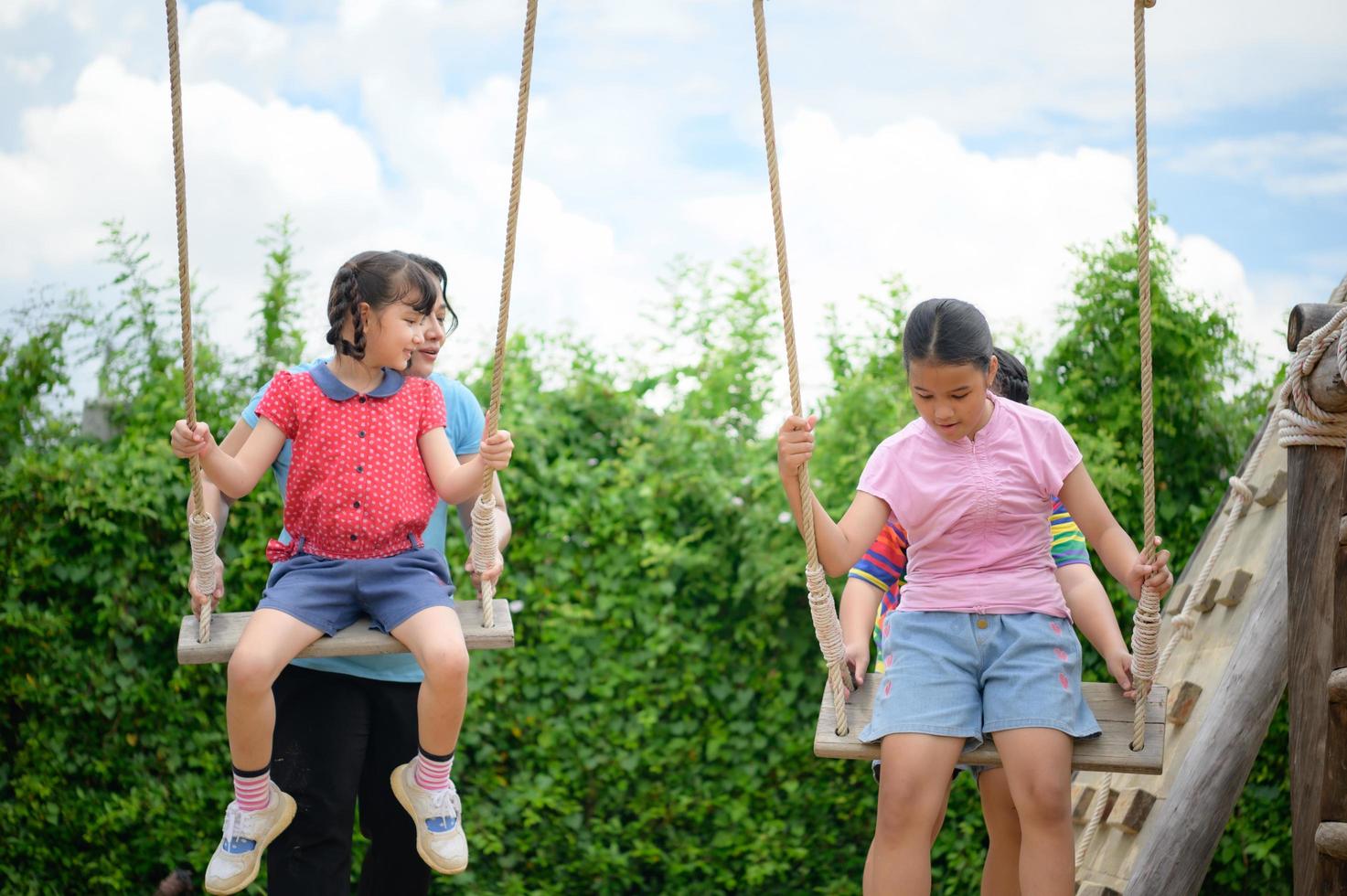Childrens having fun swinging on a swing on a clear day 14323480 Stock