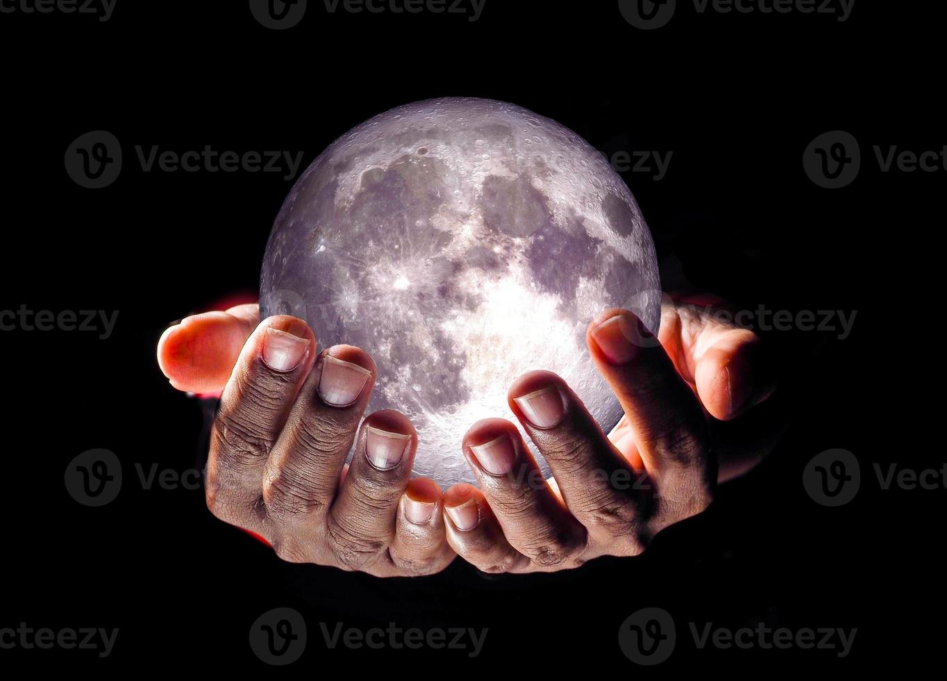 moon in hand on black background photo