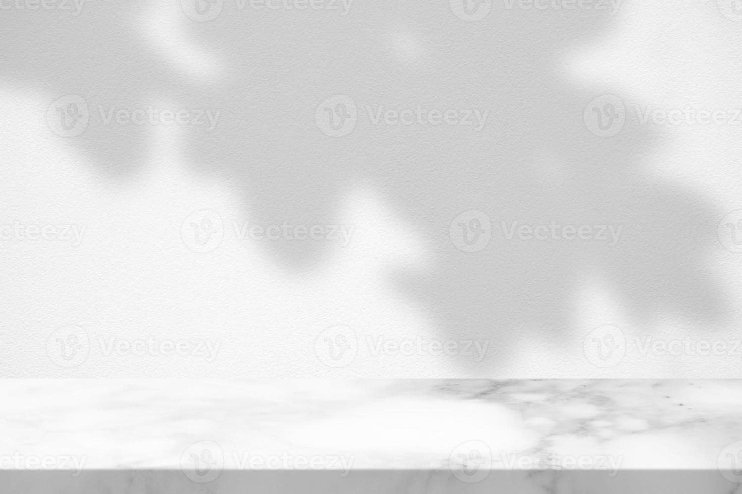 White Marble Table with Tree Leaves Shadow on Concrete Wall Texture Background, Suitable for Product Presentation Backdrop, Display, and Mock up. photo