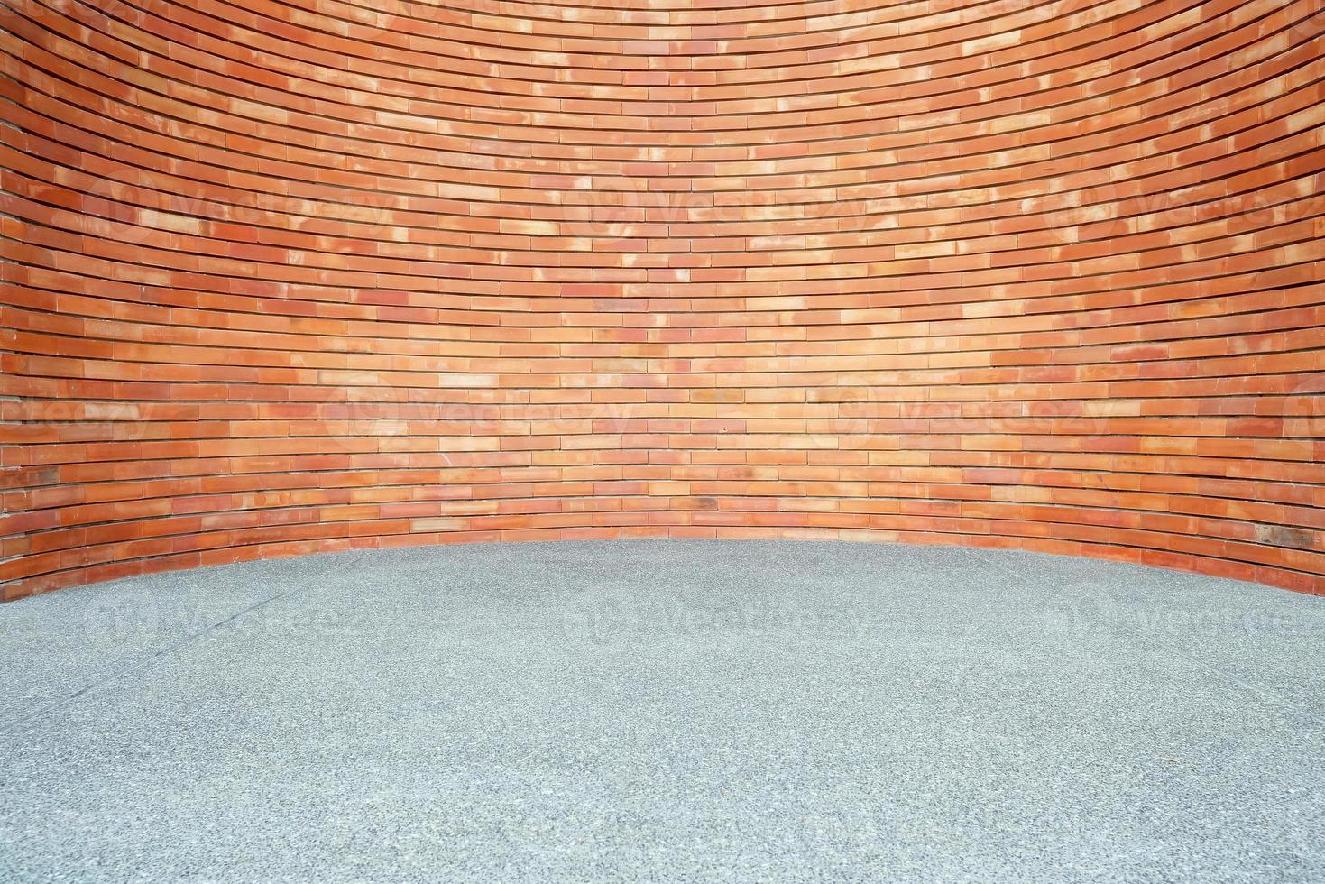 Red Brick Wall Background in Curved Style with Sand Pavement. photo