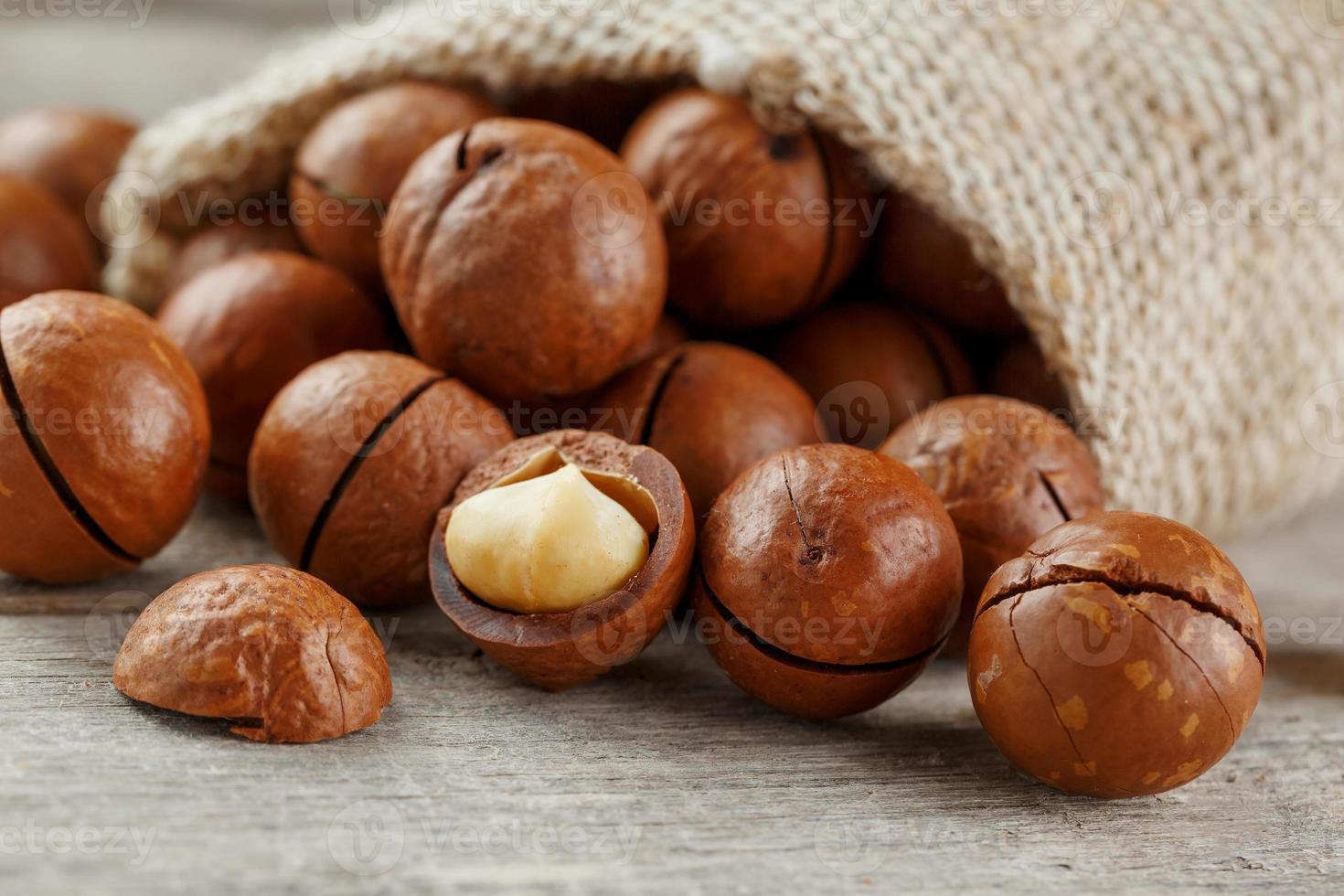 nuez de macadamia en una mesa de madera en una bolsa, primer plano, vista superior foto