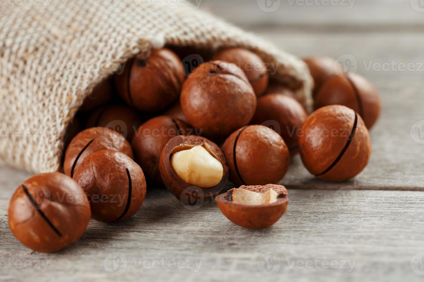 nuez de macadamia en una mesa de madera en una bolsa, primer plano, vista superior foto