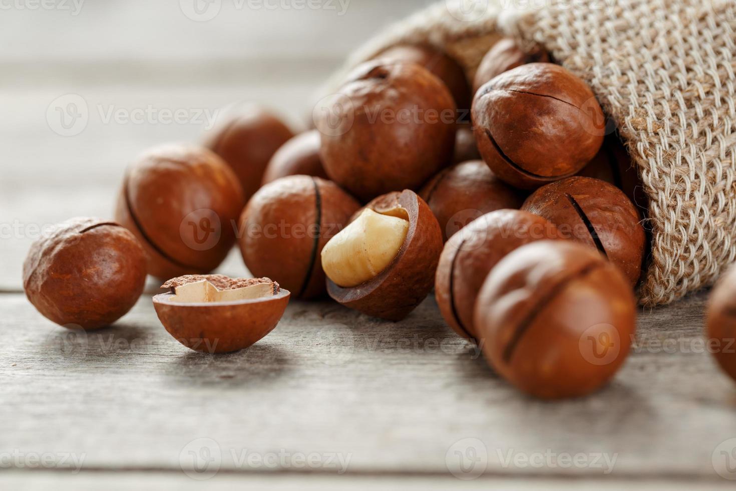 Macadamia nut on a wooden table in a bag, closeup, top view photo