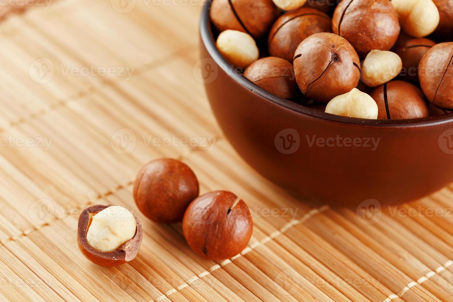 nuez de macadamia en textura de bambú, concepto de superalimentos y alimentos saludables foto